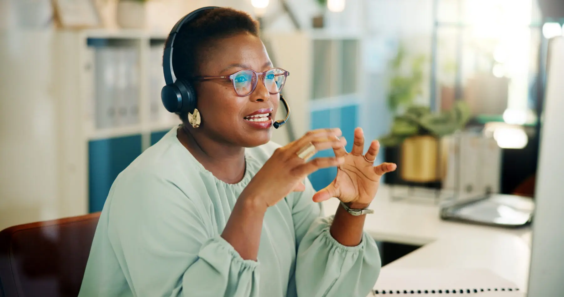 sales agent taking a call on a headset at her desk