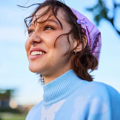happy woman wearing blue sweater looking away and smiling