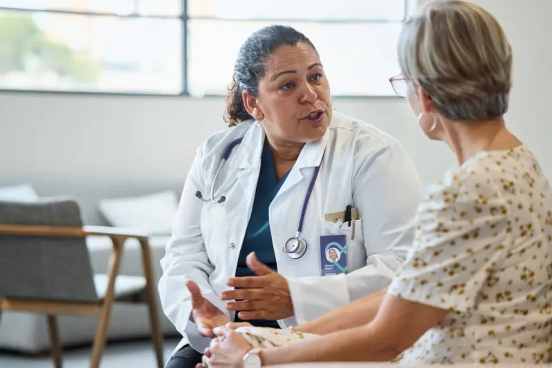 Female doctor advising senior woman at hospital
