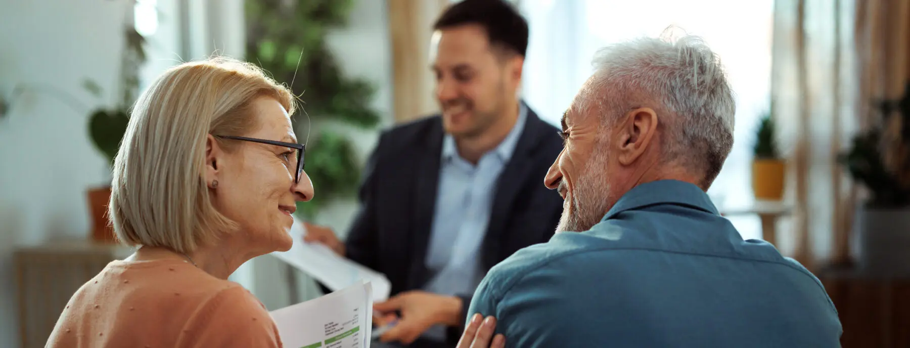 mature couple having meeting with financial advisor at their apartment