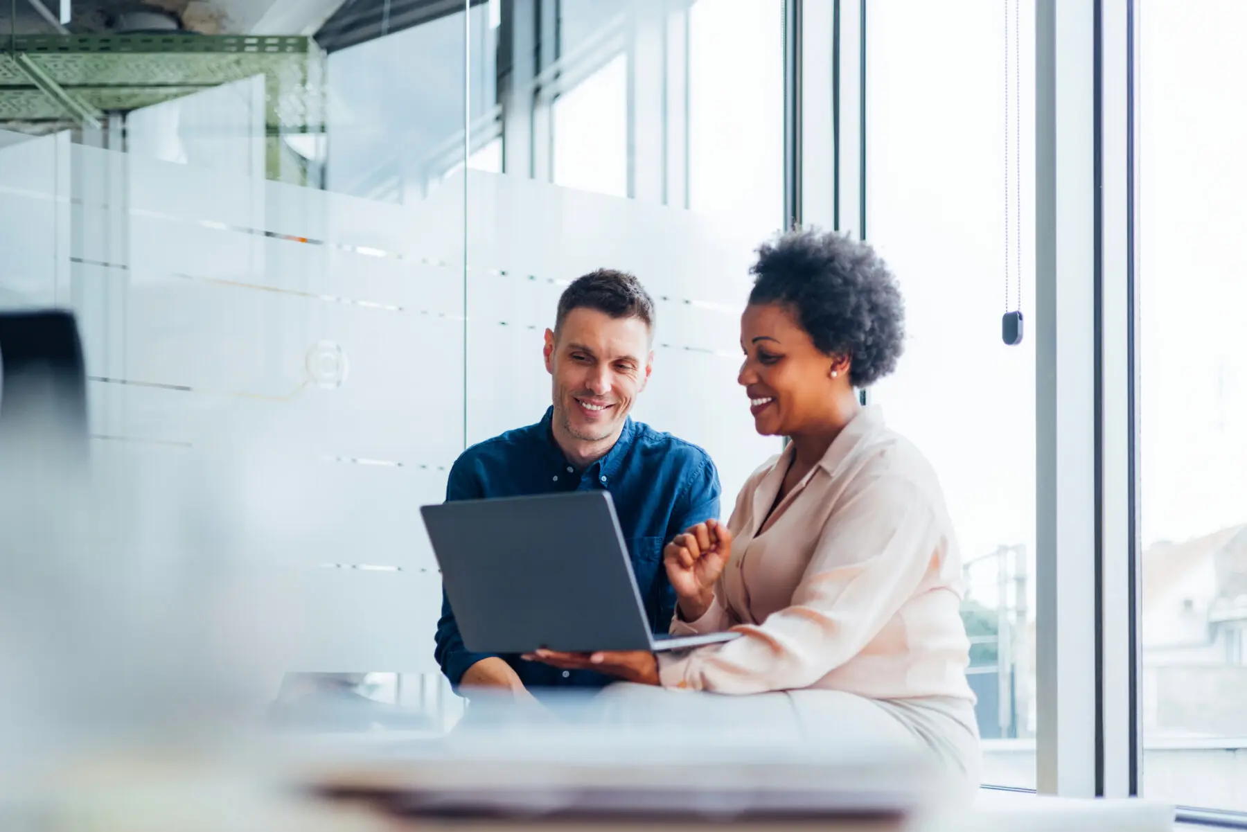 business man and woman sitting and looking at a laptop together