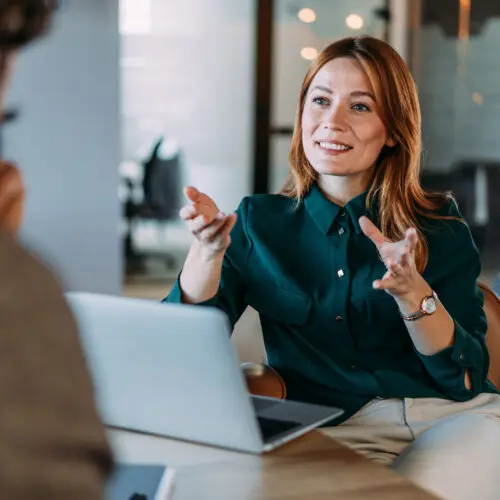 business woman speaking with a laptop speaking face to face with a client