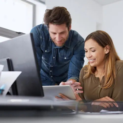 Shot of two designers discussing work on a digital tablet